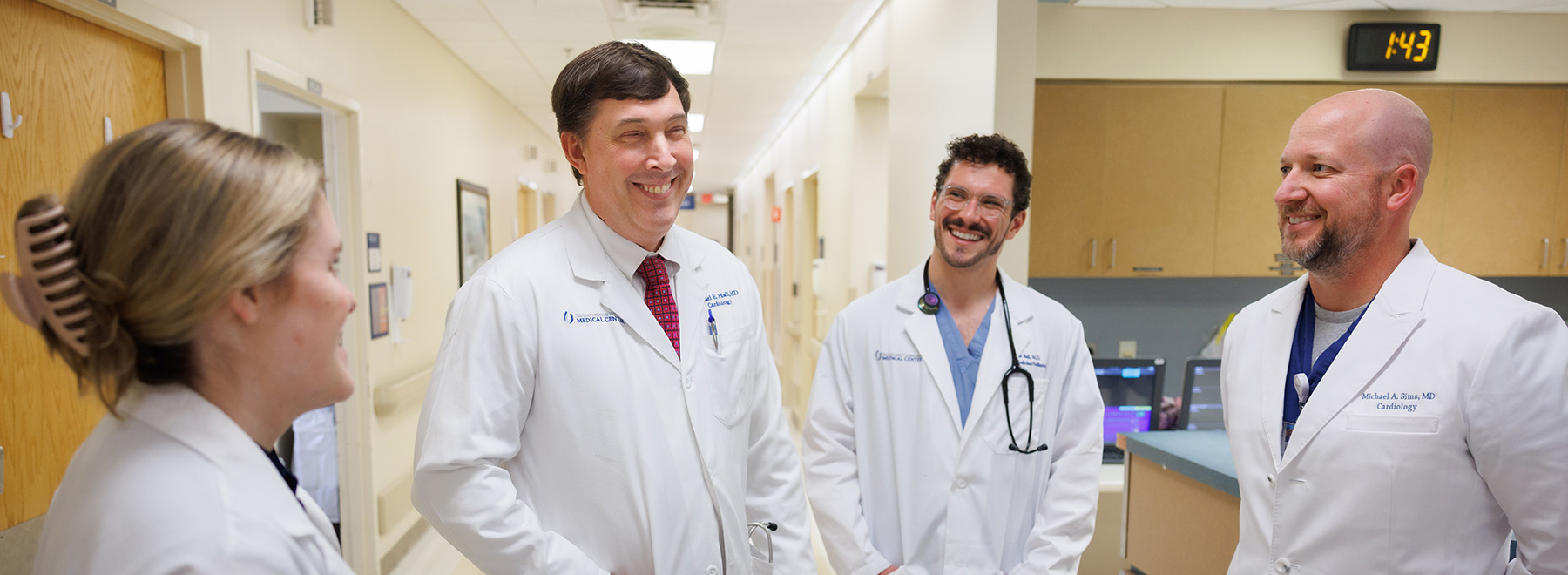 Dr. Michael Hall, second from left, standing in front of the nurses' station with three other cardiologists. Dr. Michael Hall, second from left, standing in front of the nurses' station with three other cardiologists.